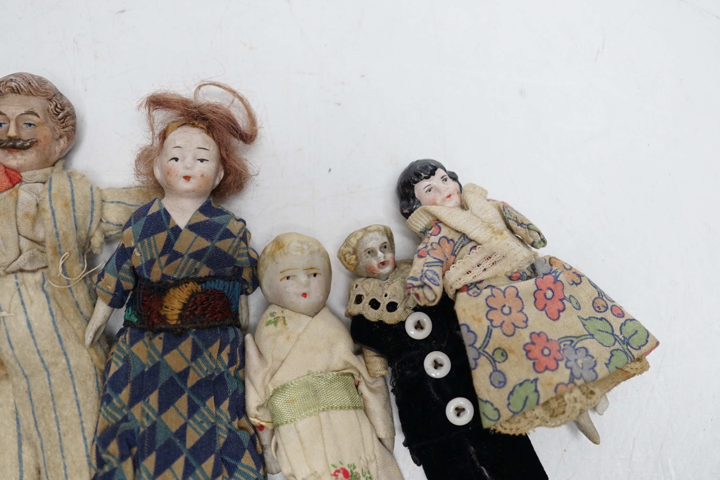 Six doll's house dolls, two c.1860 and a male figure with moustache, two other bisque later figures and one small doll, damaged